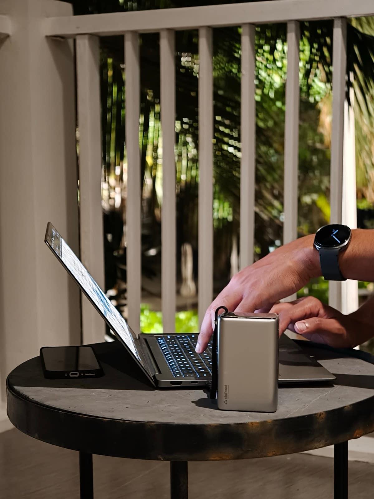 Stuffcool Giga Max powerbank — compact 100W powerbank charging a laptop